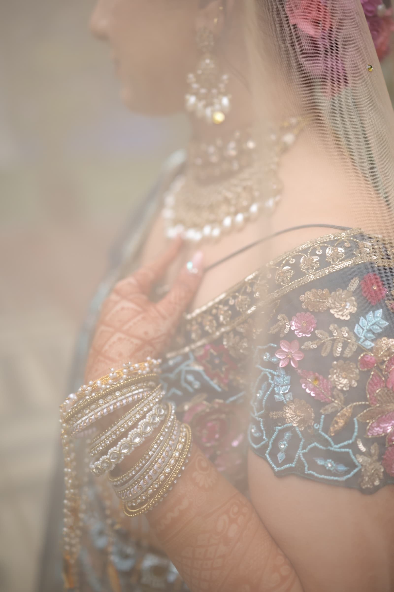 A soft-focus portrait of the bride through a sheer floral veil
